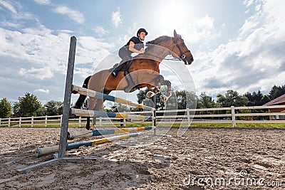Horse, ridden by a female rider, jumping over hurdles, low angle shot Stock Photo