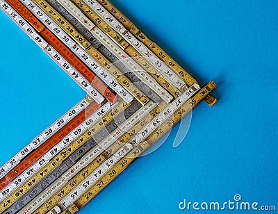A chevron or vector of old metric and inch folding rulers, concept of growth, forward movement Stock Photo