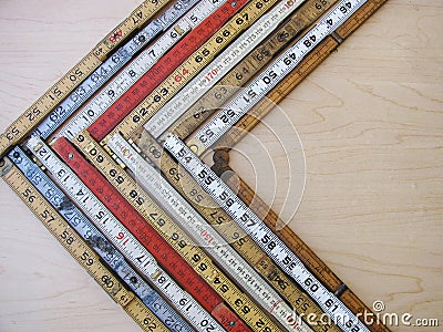 Chevron graph made of folding rulers in metric and inches representing accuracy, measurement, decrease Stock Photo