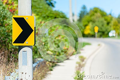 Chevron road sign indicating right turn. Stock Photo