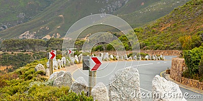 Chevron warning road sign for sharp hairpin bend on mountain pass Stock Photo