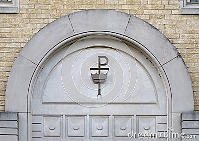 Chi Rho cross and crown above a doorway outside Christ the King Catholic Church in Dallas, Texas Stock Photo