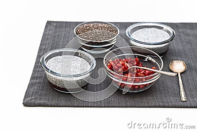 Chia seeds in a glass bowl, Chia seed pudding, and pomegranate seeds close up on white Stock Photo