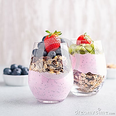 Chia seeds pudding with granola, blueberry and strawberry in glasses. Yogurt with chia seeds, berries, kiwi and muesli Stock Photo