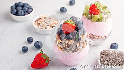 Chia seeds pudding with granola, blueberry and strawberry in glasses. Yogurt with chia seeds, berries, kiwi and muesli for healthy Stock Photo