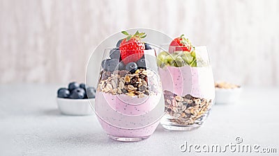 Chia seeds pudding with granola, blueberry and strawberry in glasses. Yogurt with chia seeds, berries, kiwi and muesli for healthy Stock Photo