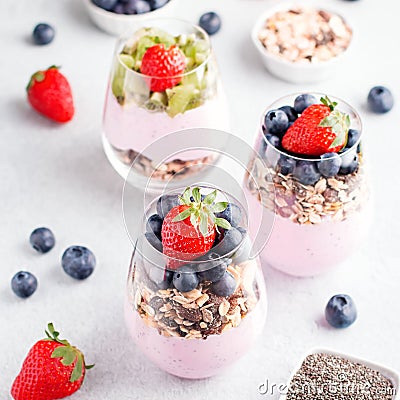 Chia seeds pudding with granola, blueberry and strawberry in glasses. Yogurt with chia seeds, berries, kiwi and muesli for healthy Stock Photo