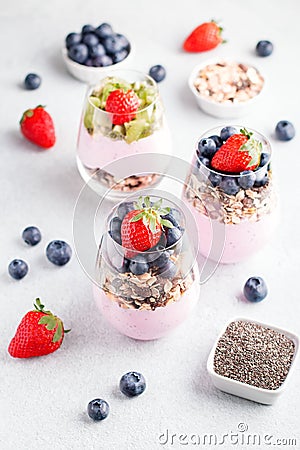 Chia seeds pudding with granola, blueberry and strawberry in glasses. Yogurt with chia seeds, berries, kiwi and muesli for healthy Stock Photo