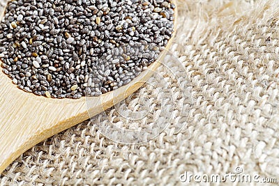 Chia seeds, super food, in wooden spoon on burlap background Stock Photo