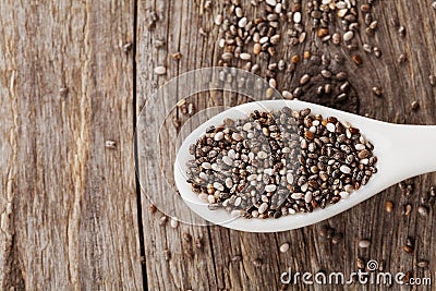 Chia seeds in white spoon on wooden Stock Photo