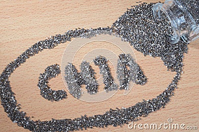 Chia word made from pouring chia seeds on wooden plate Stock Photo