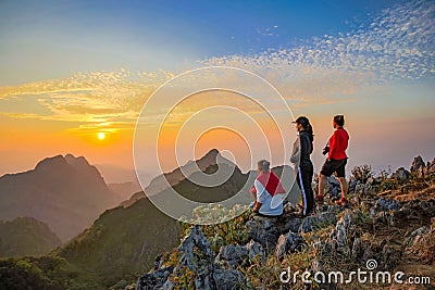 Three Asian Backpacker trekking acting over golden cloud Editorial Stock Photo