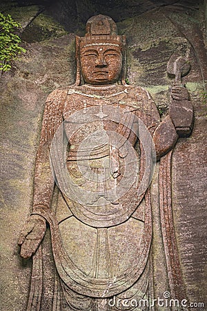 Close-up on the Hyaku-shaku kannon buddha carved in Mount Nokogiri stone quarry. Editorial Stock Photo