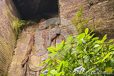 Low angle on the hyaku-shaku kannon buddha of Mount Nokogiri with a purple hydrangeas flower. Editorial Stock Photo