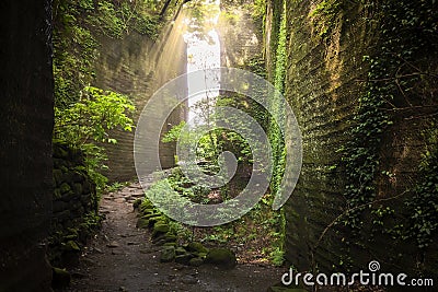 Hiking path between carved walls covered with moss in the stone quarry of Mount Nokogiri. Stock Photo