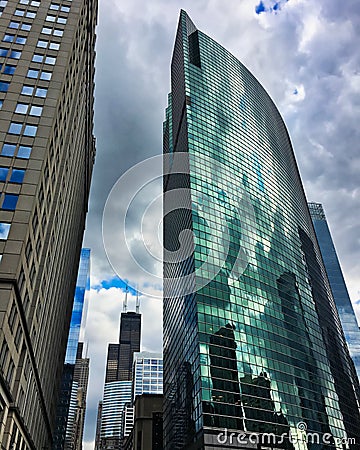 Chicago`s tallest skyscrapers on a cloudy summer day, reflecting off of mirrored buildings. Stock Photo