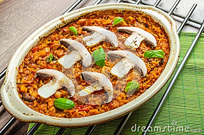 Chicken baked with rice, mushrooms and tomatoes Stock Photo