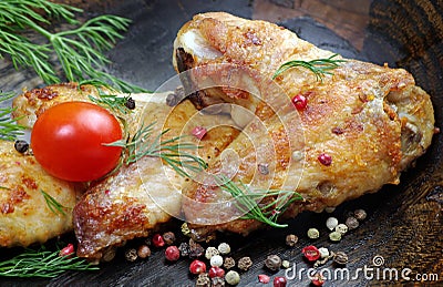 Chicken baked wings on wooden background. chicken wings, tomatoes and pepper mix, Stock Photo