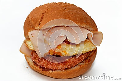 Chicken breast burger with fried egg, tomato slice, smoked turkey ham in a bun bread sandwich with ketchup and mayonnaise, Stock Photo