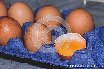 Chicken eggs with one broken fresh raw orange yolk in shell Stock Photo