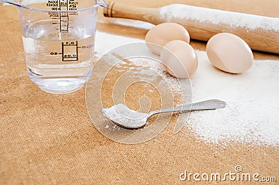 Chicken eggs, water, flour and a rocking chair on the table. Stock Photo