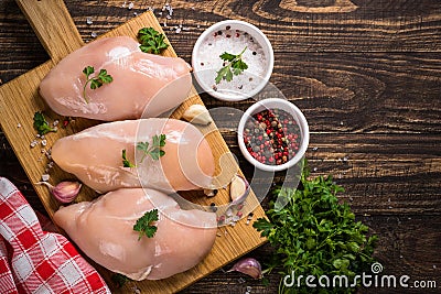 Chicken fillet with ingredients for cooking on wooden table. Stock Photo