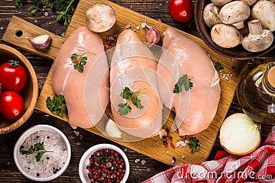 Chicken fillet with ingredients for cooking on wooden table. Stock Photo