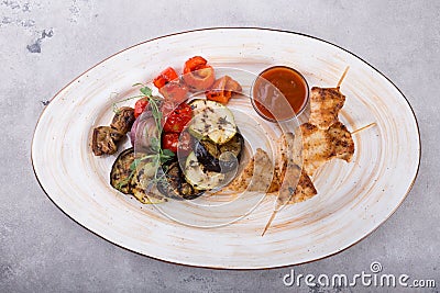 Chicken grilled on wooden skewers with vegetables Stock Photo