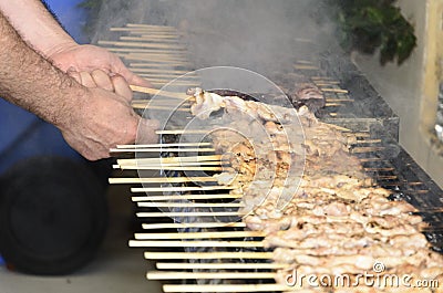 Chicken kebabs on the grill and human hands Stock Photo