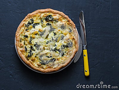 Chicken, leek, cheese, spinach quiche on dark background Stock Photo