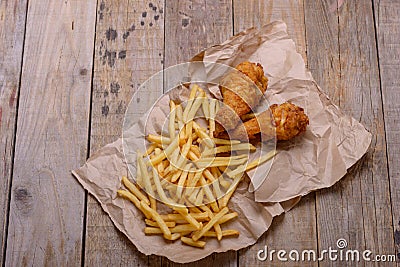 Chicken legs and french frie on wooden background Stock Photo