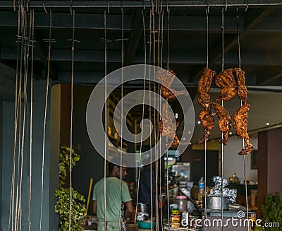 Chicken legs hanging on skewers in an Indian restaurant Editorial Stock Photo