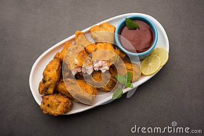 indian starter chicken pakora or pakoda or fritter served with tomato ketchup Stock Photo