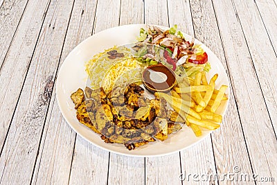 Chicken shawarma plate with pilau rice, potatoes fries and turkish salad Stock Photo