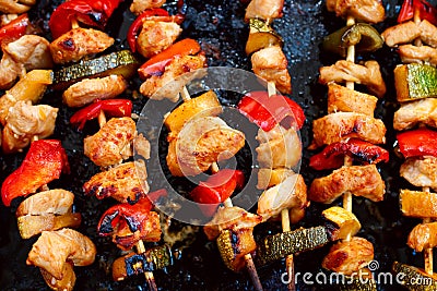 Chicken teriyaki kebabs with vegetables on black baking Stock Photo