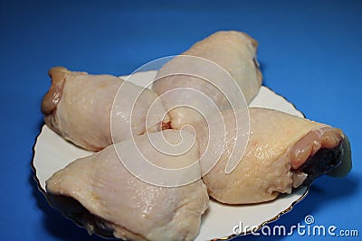 Chicken thighs on a blue background. Stock Photo