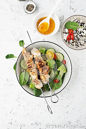 Chicken turkey skewers with fresh vegetables: spinach, hot pepper, romanesque, broccoflower, cherry tomatoes. Top view Stock Photo