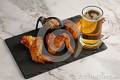 Chicken wings and beer. Hearty and tasty food. Plate of delicious barbecue chicken wings Stock Photo