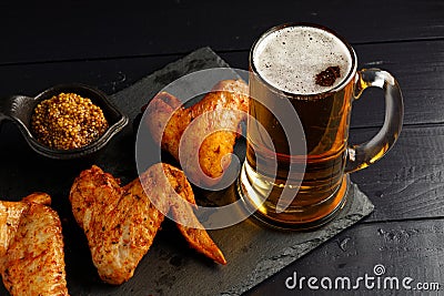 Chicken wings and beer. Hearty and tasty food. Plate of delicious barbecue chicken wings Stock Photo