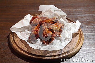 Chicken wings in hot sauce, specially prepared for beer. Chicken baked wings on wooden background. Stock Photo