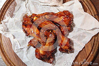 Chicken wings in hot sauce, specially prepared for beer. Chicken baked wings on wooden background. Stock Photo