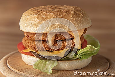 chickenburger centred on wooden plate close up Stock Photo