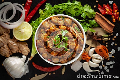 Chickpeas masala Spicy chola or chhole curry garnished with fresh green coriander and ingredients. Served in a ceramic bowl. Stock Photo