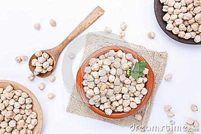 Chickpeas on plates and wooden spoon on white background. Top view Stock Photo