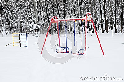 Chidren playground covered snow with colorful swing Stock Photo