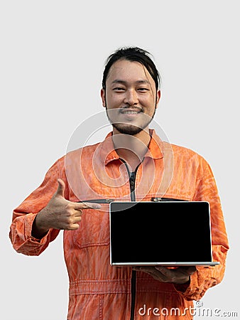 The chief mechanic in an orange uniform holding blank screen laptop Stock Photo