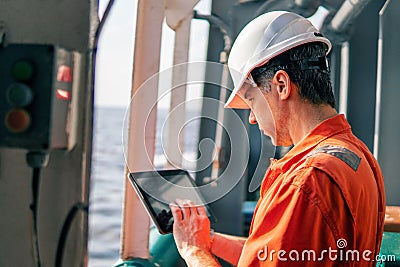 Chief officer or captain on deck of vessel or ship watching digital tablet Stock Photo