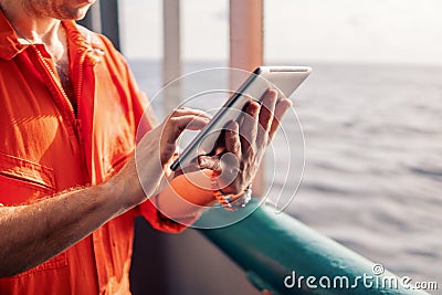 Chief officer or captain on deck of vessel or ship watching digital tablet Stock Photo