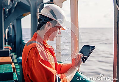 Chief officer or captain on deck of vessel or ship watching digital tablet Stock Photo