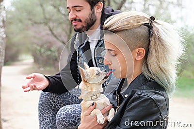 Chihuahua licking her owners mouth and disgusted friend beside Stock Photo